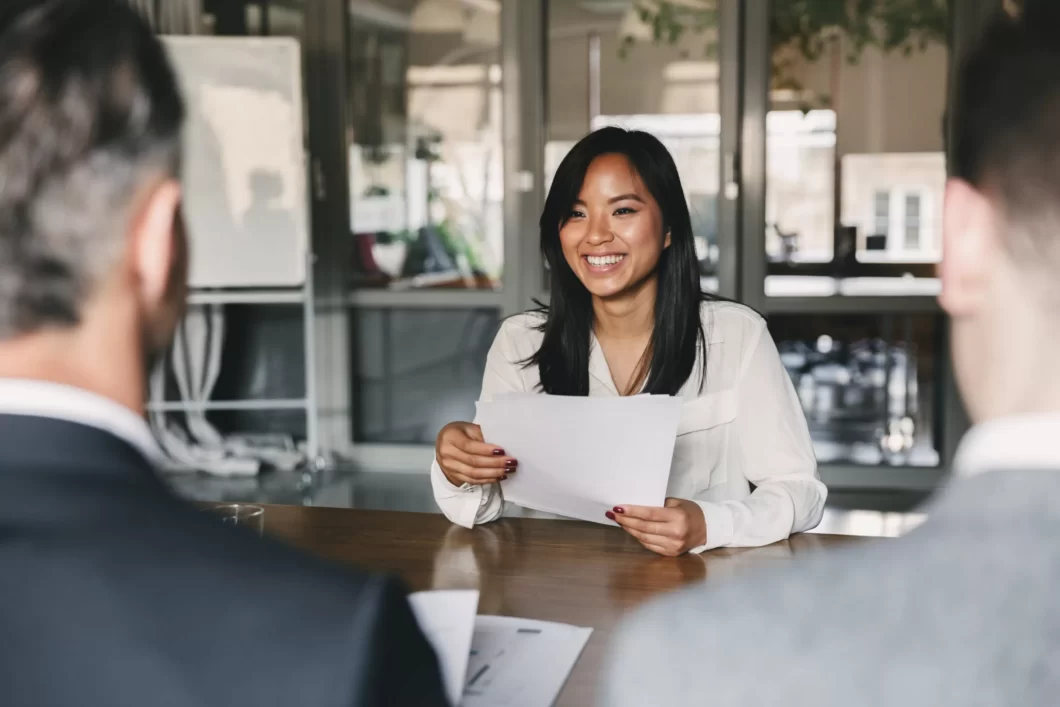 5 Top Resume Writing Tips: How To Make Your Resume Stand Out with woman smiling in an office room.